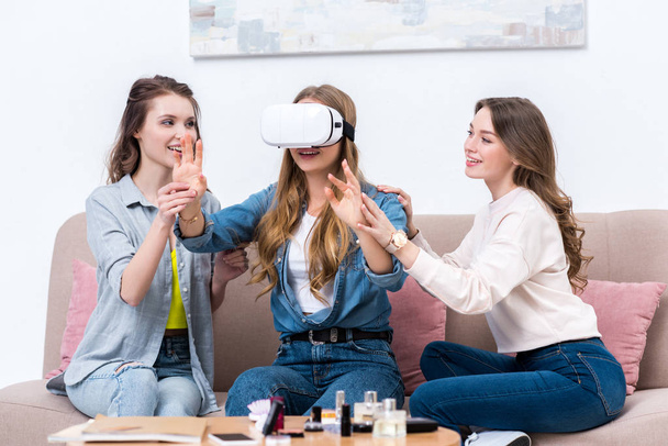 smiling young girlfriends having fun together with virtual reality headset - Valokuva, kuva