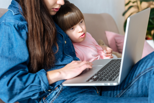 Anne ve kızı dizüstü bilgisayar ekranına bakarak down sendromlu - Fotoğraf, Görsel