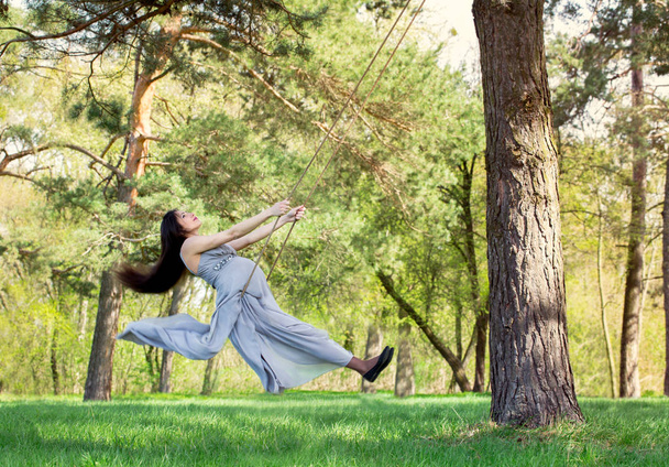 pregnant woman swinging on a swing - Fotoğraf, Görsel