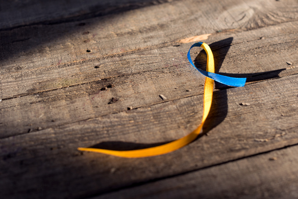 ダウン症の日の背景の木製の背景の青と黄色のリボン - 写真・画像