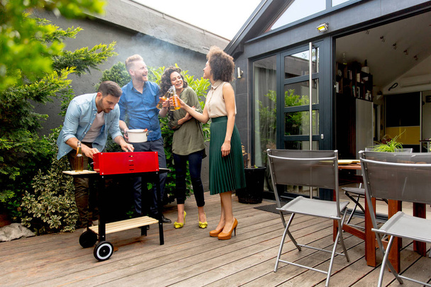 Zobacz w happy friends grillowaniu potraw i ciesząc się grill party na zewnątrz - Zdjęcie, obraz