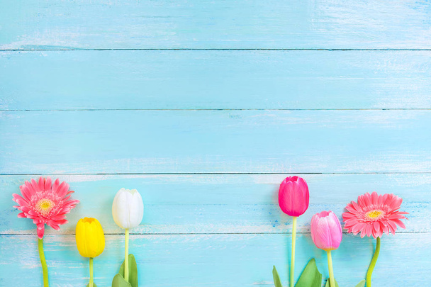 Diferentes tipos de flores coloridas em linha no fundo de madeira azul. vista superior e design de fronteira, flor de fundo de primavera ou verão
 - Foto, Imagem