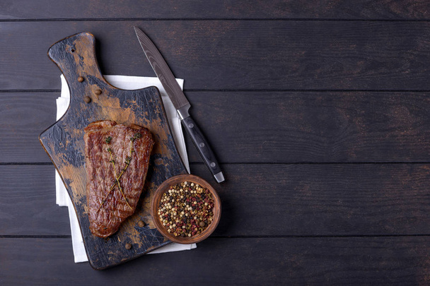 Beef steak on cutting board and pepper - Photo, Image