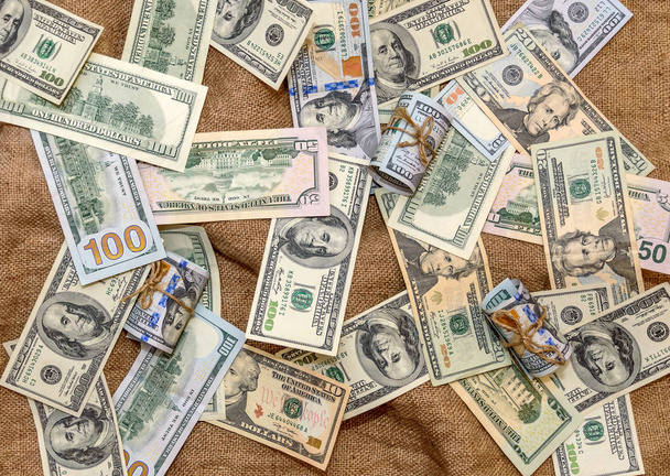 Dollars américains billets et dollars billets enroulés sur une toile de jute backgrou
 - Photo, image