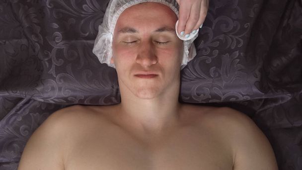Primer plano de una limpieza facial. Hombre en el salón de spa en el procedimiento
 - Foto, Imagen