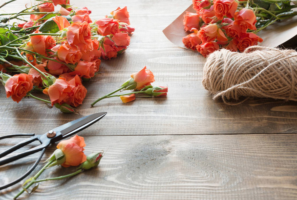 Working table florista.Preparation a bouquet of orange shrub roses. - Fotó, kép