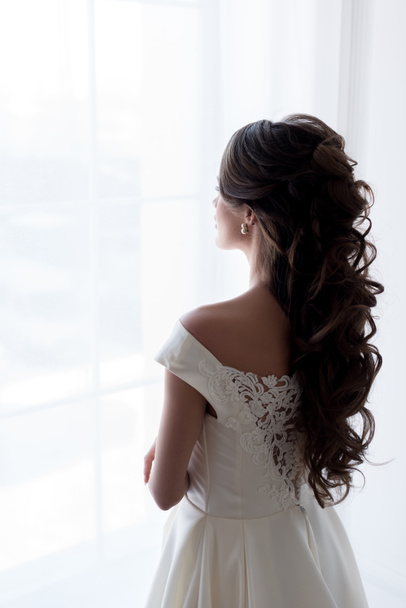 ウィンドウを見てウェディング ドレスの花嫁の背面図 - 写真・画像