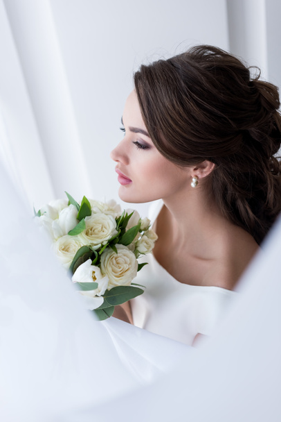 mladá bruneta nevěsta drží svatební kytice - Fotografie, Obrázek