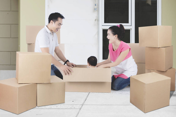 Young Asian family unpacking boxes in their new home - Foto, Imagem