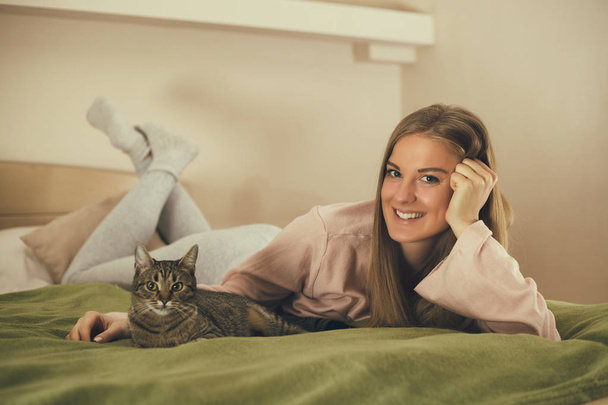 Beautiful woman and her cute cat enjoy spending time together.  Image is intentionally toned. - Fotoğraf, Görsel
