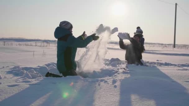冬の新鮮な空気で遊んでいる子供たちは、雪玉を投げます。アクティブなアウトドア スポーツ - 映像、動画