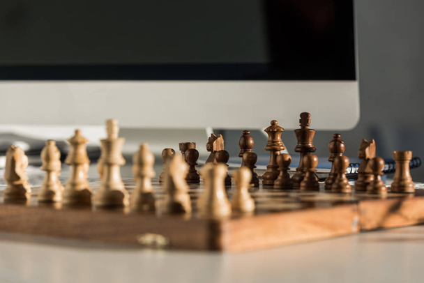 close-up shot of chess board at workplace near computer - Zdjęcie, obraz