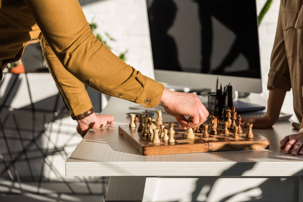 oříznutý snímek manažerů hrát šachy na pracovní stůl - Fotografie, Obrázek