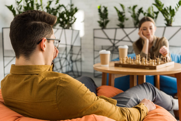 Koncentrovaná mladý muž a žena hrající šachy - Fotografie, Obrázek
