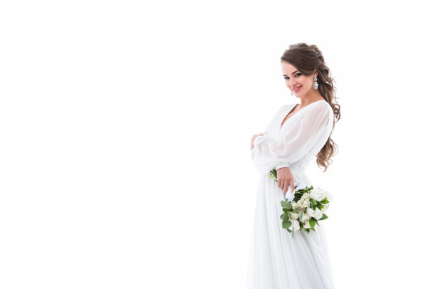 smiling bride posing in white traditional dress with wedding bouquet, isolated on white - Foto, immagini