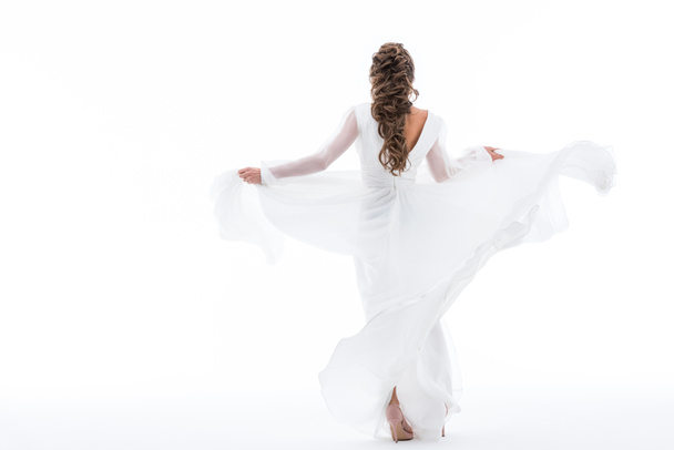 back view of elegant bride dancing in traditional wedding dress, isolated on white - Φωτογραφία, εικόνα