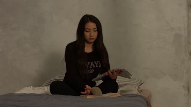 Asian high school girl studying on bed at home - Záběry, video