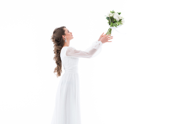 elegant bride in white dress throwing wedding bouquet, isolated on white - Foto, afbeelding
