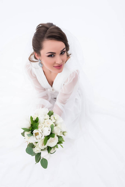 smiling bride in traditional white dress holding wedding bouquet, isolated on white - Photo, Image