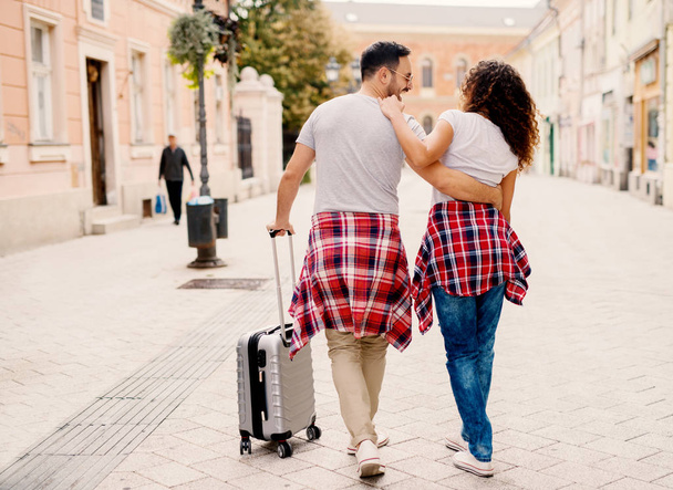 couple voyageant en ville avec des bagages
  - Photo, image