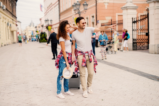 молодая счастливая влюбленная пара путешествующая по городу и держащаяся за руки
 - Фото, изображение