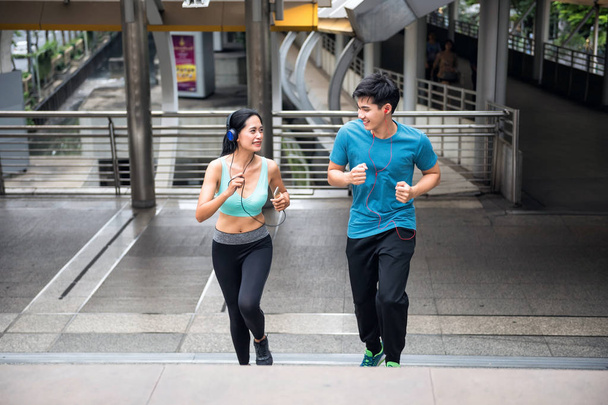 Saludable pareja asiática corriendo en la ciudad
 - Foto, imagen