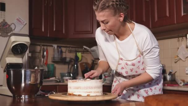 Νεαρή γυναίκα εργάζεται στην κουζίνα, προετοιμασία γλυκό επιδόρπιο τούρτα - Πλάνα, βίντεο