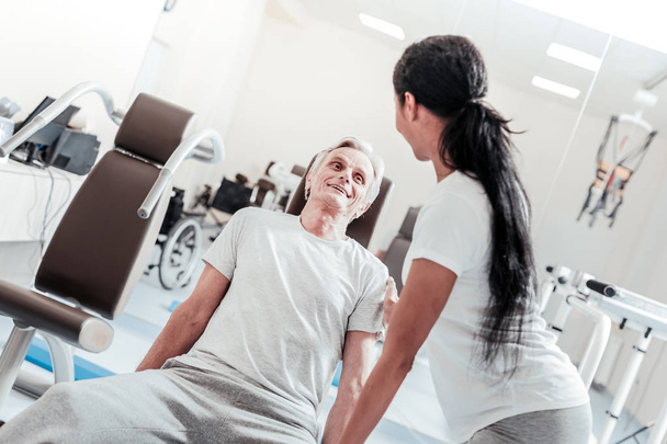 Cheerful baby-boomer exercising and a trainer near him - Foto, Bild