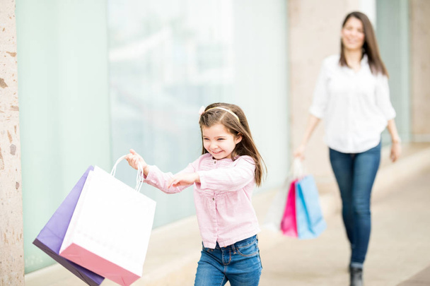 Tochter läuft vor Einkaufszentrum vor Mutter weg  - Foto, Bild