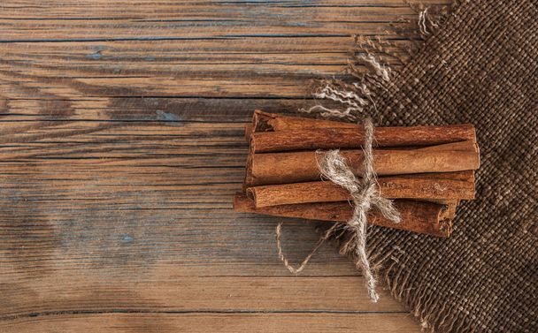 Cinnamon sticks bunch tied with rope on a dark background - Fotoğraf, Görsel
