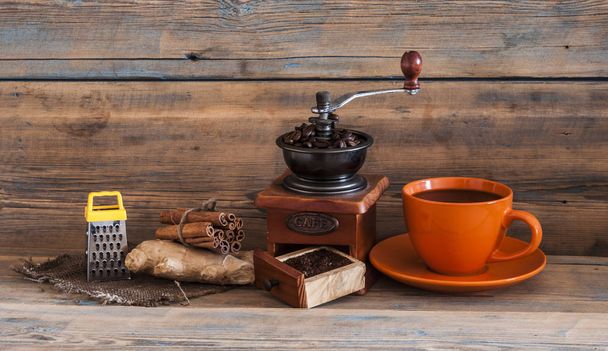 натюрморт с кофейными зёрнами и старой кофейной мельницей на деревянном столе
 - Фото, изображение