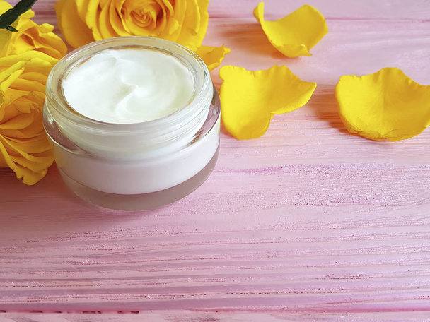 cosmetic cream, yellow rose on a pink wooden - Photo, Image