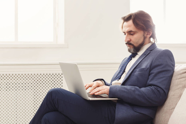Homme d'affaires concentré travaillant avec un ordinateur portable
 - Photo, image