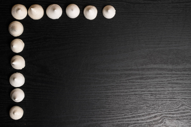 deliciosos merengues sobre el fondo negro de madera
 - Foto, imagen