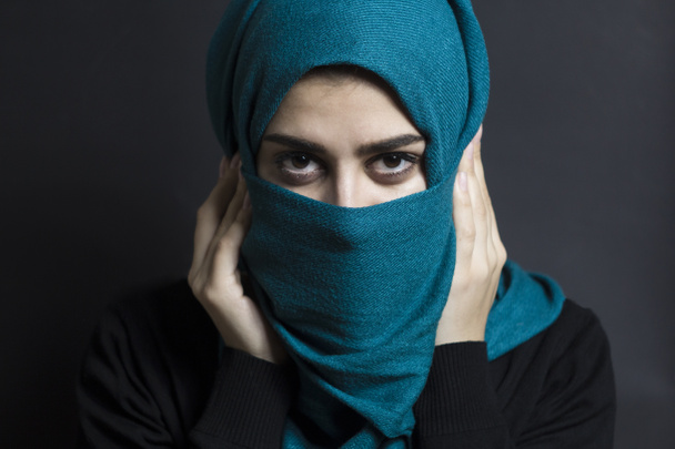 Πορτραίτο μουσουλμάνου κοριτσιού σε μαύρο φόντο. Αραβίδα με όμορφα μάτια. - Φωτογραφία, εικόνα