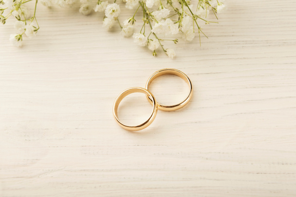 Two golden wedding rings with flower decorations - 写真・画像