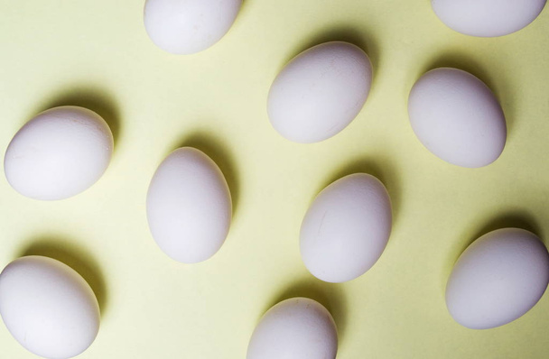White eggs on yellow background flat lay - Foto, afbeelding