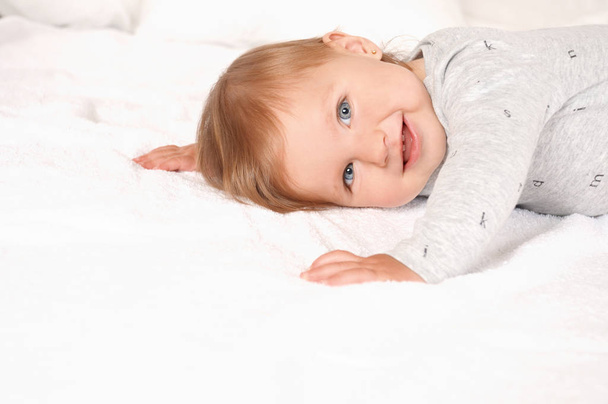 Portrait of a sweet girl lying on the bed at home - Foto, Imagen