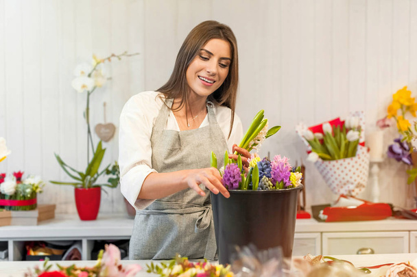 Usmívající se žena květinářství majitel malé firmy flower shop, u přepážky hyacinth, přijetí opatření. - Fotografie, Obrázek