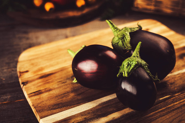 Eggplants on vintage wooden background - Фото, изображение