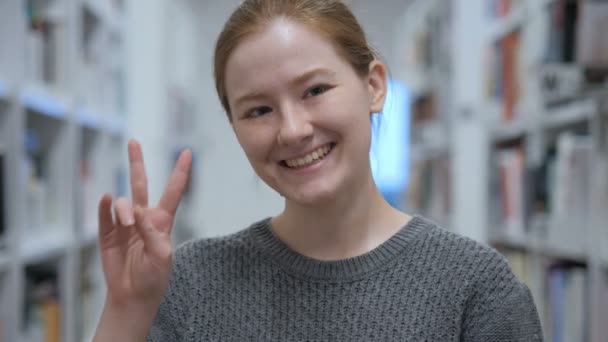 Portrait of Young Woman Gesturing Victory Sign in Cafe - Materiaali, video