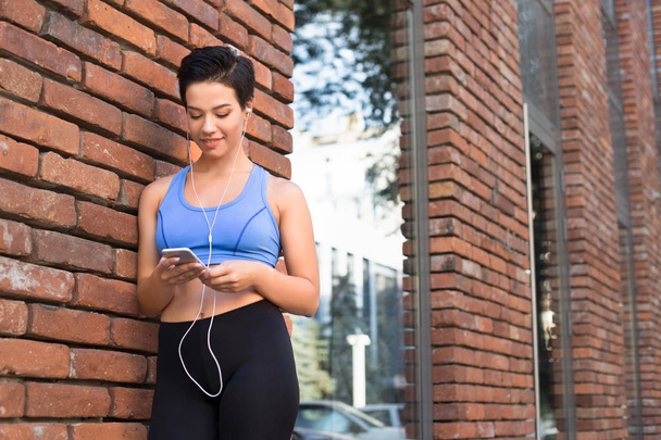 Femme choisir la musique à écouter pendant le jogging
 - Photo, image