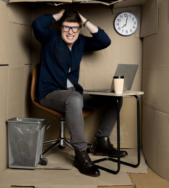 Young employee is feeling rage inside small paper room - Foto, Imagem