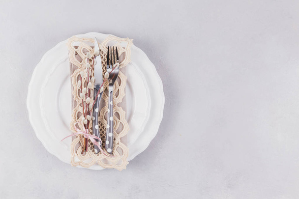 White plate, cutlery, lace napkin and pussy willow twigs - Zdjęcie, obraz