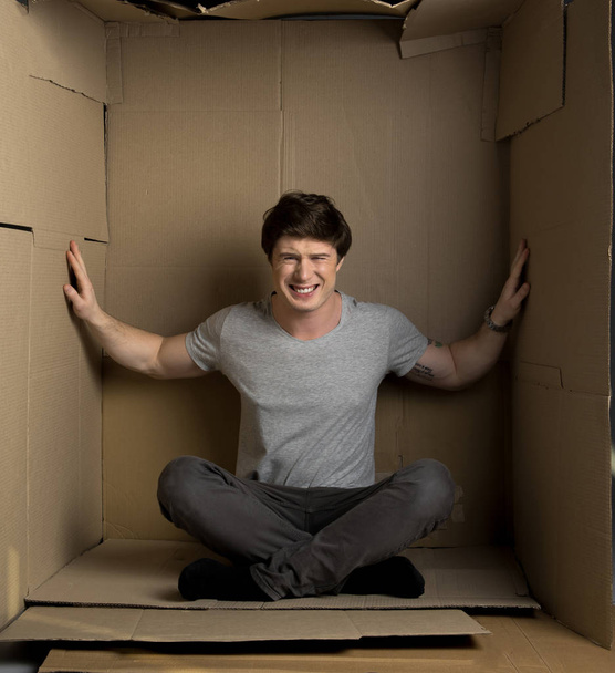 Guy is feeling discomfort in cramped room - Fotografie, Obrázek