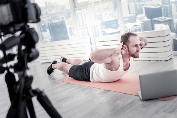 Confident male blogger performing exercise - Foto, Bild