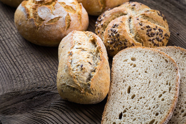 Verschiedene Arten von frischem Brot auf Holztisch.  - Foto, Bild