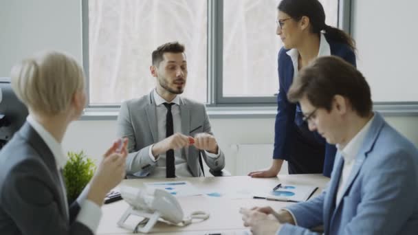 Businessman discussing future business project with male and female colleagues sitting at the table in modern office - Imágenes, Vídeo