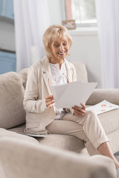 Pleasant mature businesswoman studying business plan - Foto, afbeelding