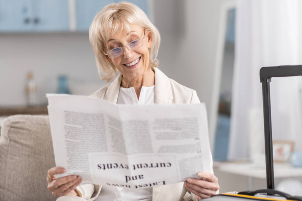 Αισιόδοξη ώριμη γυναίκα ανάγνωση εφημερίδων - Φωτογραφία, εικόνα